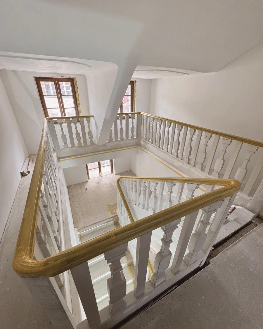 Treppenhaus eines Altbaus mit Holzgeländer während der Renovation