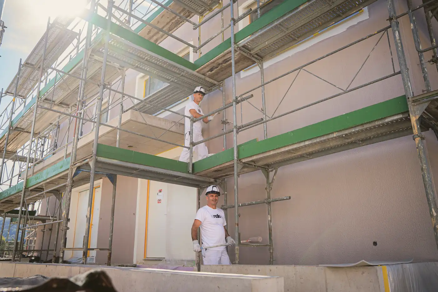 Andisa-Mitarbeiter auf dem Gerüst vor einer Fassade