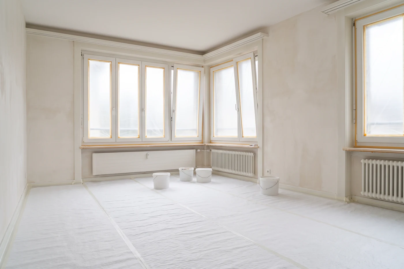 Innenausbau: ein leerer Raum in Renovation mit frisch verputzten Wänden und Tageslicht