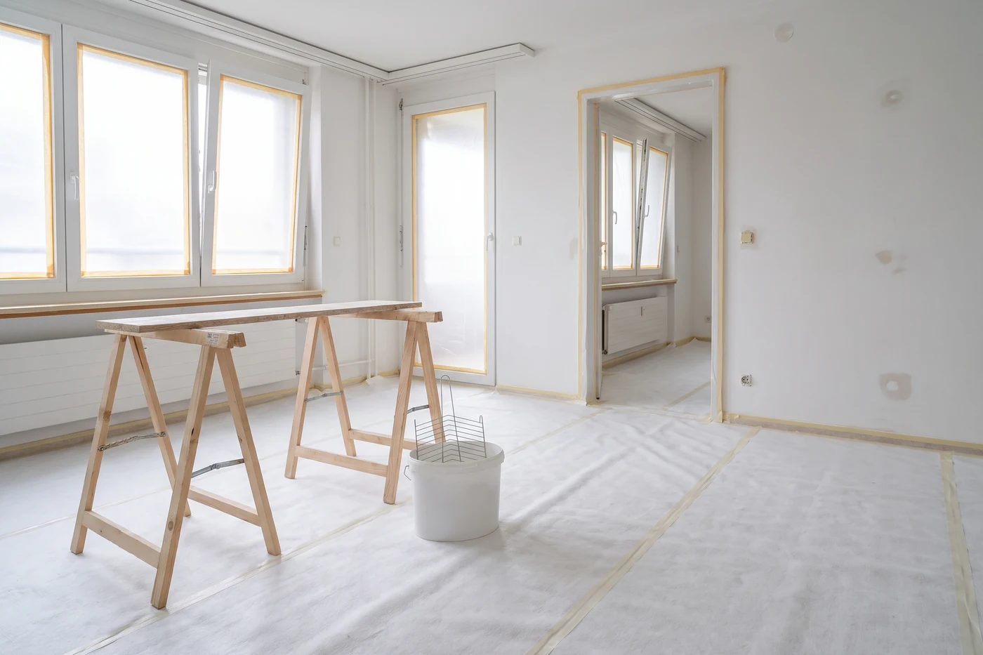 Wohnung im Umbau mit Floorliner am Boden, Malerböcken und vorbereiteten Wänden