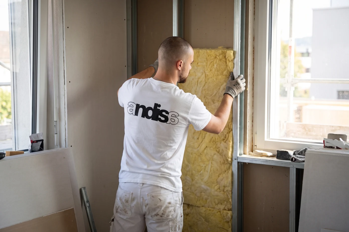 Mineralwolle wird zwischen die Ständer einer neuen Wand gesetzt